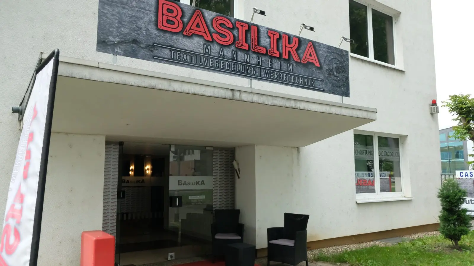 Basilika-Fahne und Schild am Geschäft in Mannheim-Neckarau